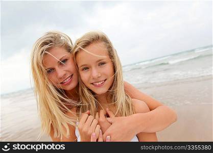 Blond woman and young girl on a sandy beach