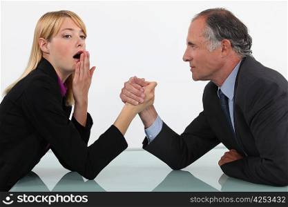 Blond woman arm wrestling her boss