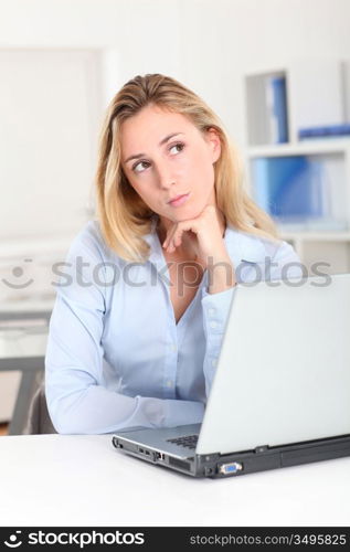 Blond woman at work with thoughtful look