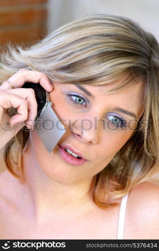 Blond woman chatting to her friend on the phone