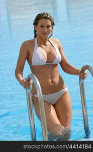 Blond woman climbing out of pool