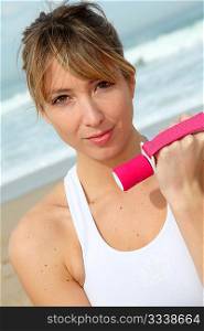 Blond woman doing fitness exercises on the beach