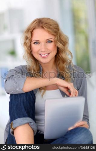 Blond woman doing online shopping with digital tablet