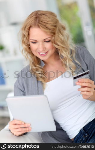 Blond woman doing online shopping with digital tablet