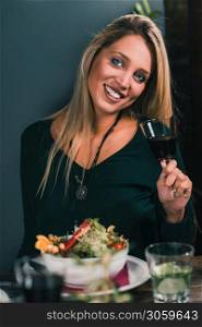 Blond Woman Drinking Red Wine in restaurant