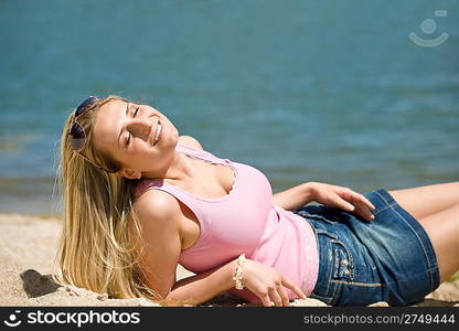 Blond woman enjoy summer sun lying on beach