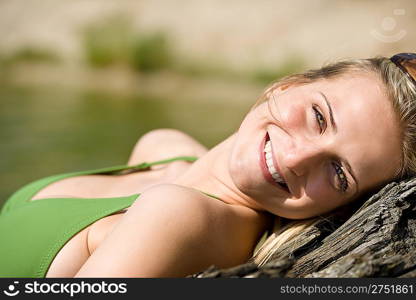 Blond woman enjoy summer sun wearing bikini at lake