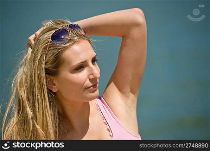 Blond woman enjoy summer sun wearing sunglasses, at sea