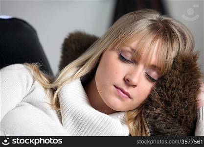 Blond woman having a nap on sofa