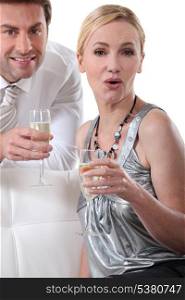 Blond woman holding champagne glass surprised expression
