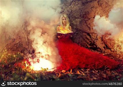 Blond woman holding firing magic book
