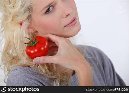 Blond woman holding tomato
