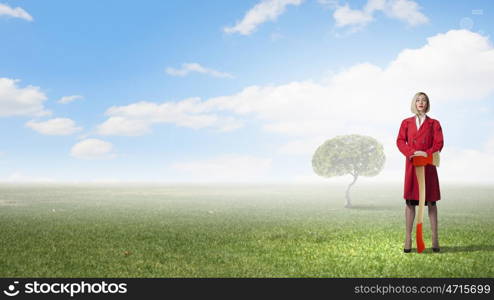 Blond woman in red coat with axe and green tree. Protect forests