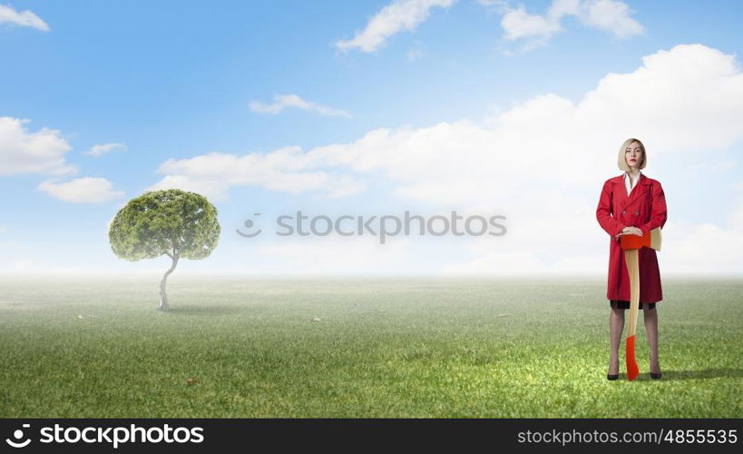 Blond woman in red coat with axe and green tree. Protect forests