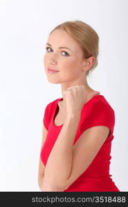 Blond woman in red shirt designating something with thumb up