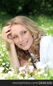 Blond woman laying in a field of daisies