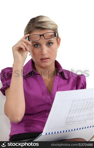 Blond woman lifting glasses to see better