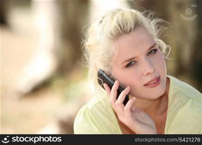 Blond woman making call outdoors