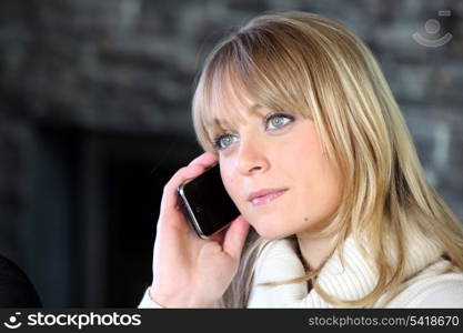 Blond woman making telephone call from home