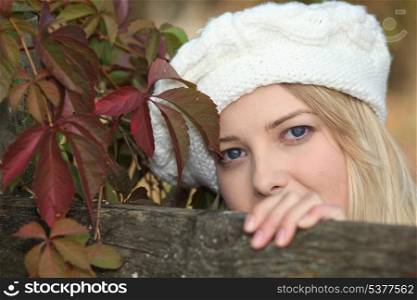 Blond woman posing by fence