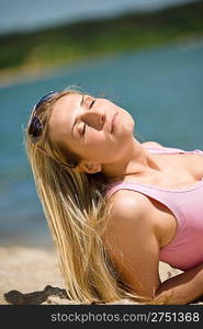 Blond woman relax in summer sun lying on beach