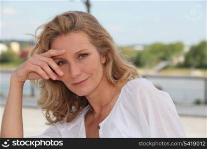 Blond woman relaxing by river front