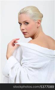 Blond woman removing bathing robe
