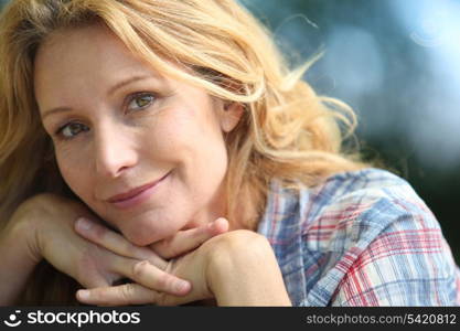 Blond woman resting chin on hands