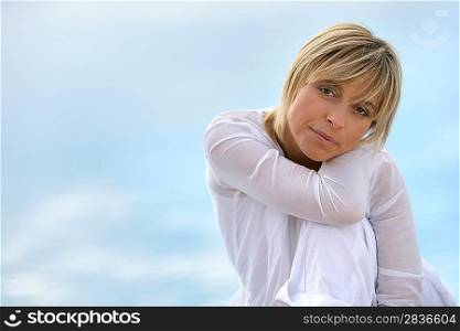 Blond woman sat touching shoulder