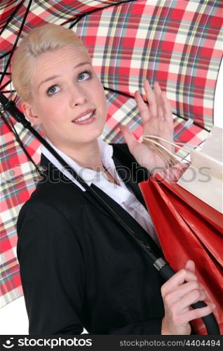 Blond woman shopping under the rain.