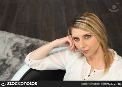 Blond woman sitting on a sofa