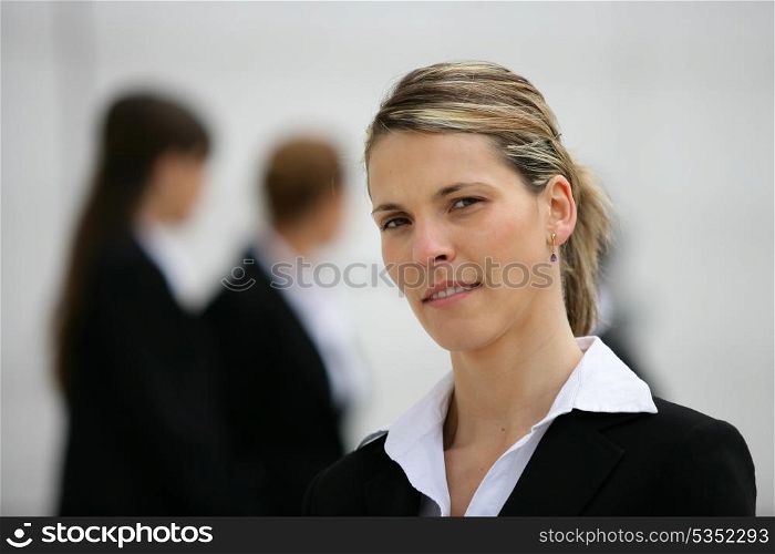 Blond woman stood with colleagues in background