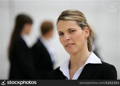 Blond woman stood with colleagues in background