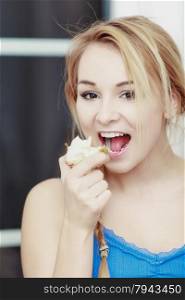 Blond woman teenage girl with braid eating apple healthy fruit. Diet and nutrition. Indoor.
