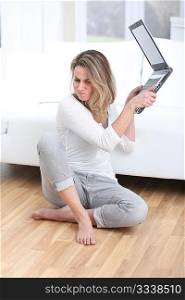 Blond woman throwing laptop computer on the floor