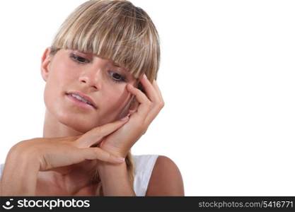 Blond woman touching face