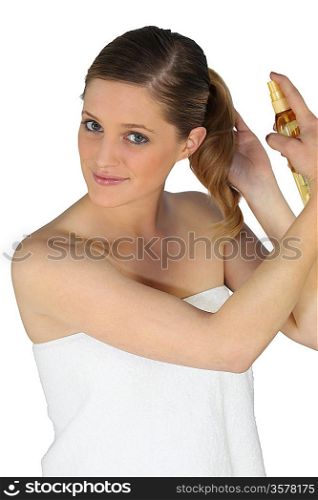 Blond woman using hair spray