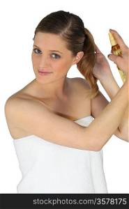Blond woman using hair spray