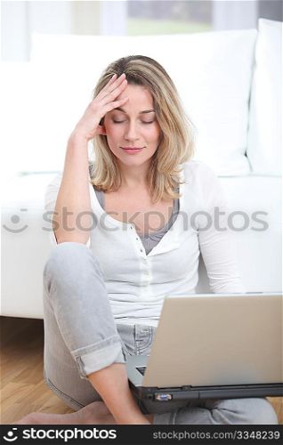 Blond woman using laptop computer at home