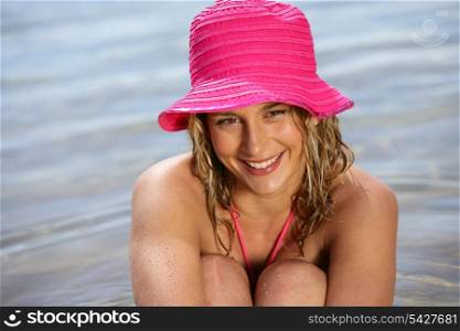 Blond woman wearing pink hat at the beach