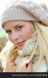 Blond woman wearing wool cap in autumn