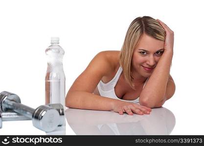 Blond woman with bottle of water and weights on white background