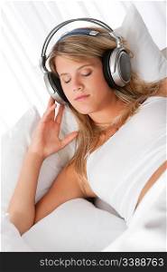 Blond woman with headphones listening to music with closed eyes