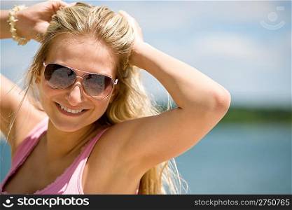Blond woman with sunglasses enjoy sunny day on seashore