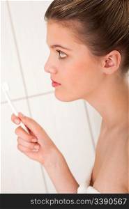 Blond woman with white toothbrush in the bathroom