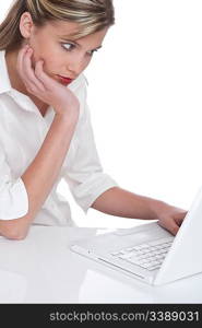 Blond woman working with laptop on white background