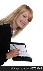 Blond woman writing in her agenda