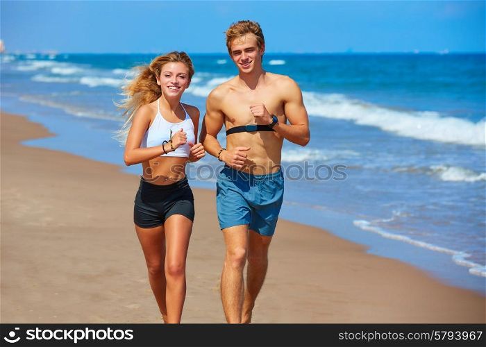 Blond young couple running on the beach in summer vacation