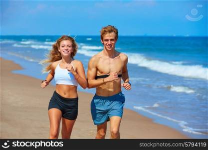 Blond young couple running on the beach in summer vacation
