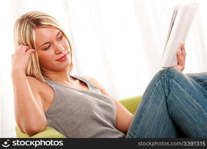Blond young woman reading book